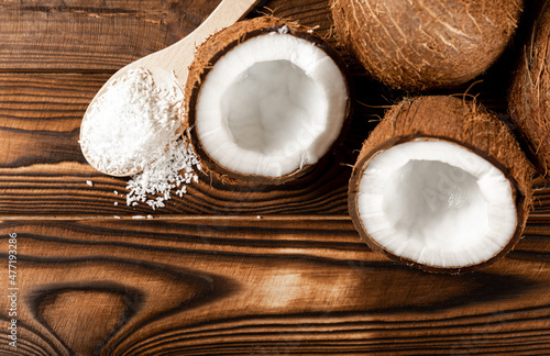 coconut flakes on a wooden spoon, coconuts on a wooden background. Close-up. copy space.