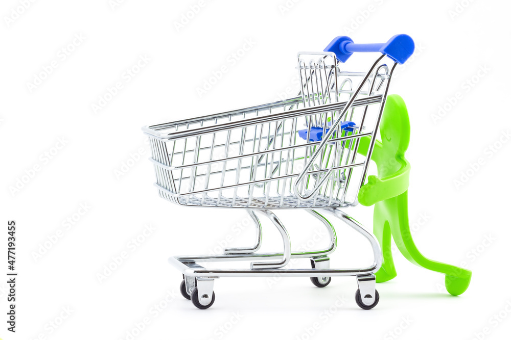 Green plastic toy abstract man pushing empty shopping trolley. Shopping time in supermarkets and malls. Holiday sales concept background. Green plastic toy abstract man pushing empty shopping trolley. Shopping time in supermarkets and malls. Holiday sales concept background.