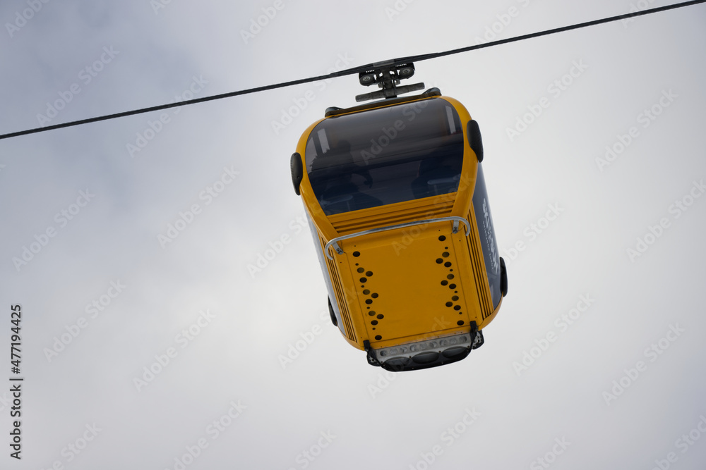 Cable car cabin going up and down at a winter sports resort area on a cloudy day. Cable car cabin going up and down at a winter sports resort area on a cloudy day.