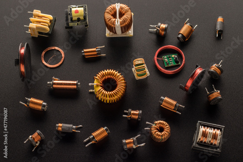 Inductors with a ferrite core, inductor copper coil, and also round RFID Antenna copper coil  on a black background, top view