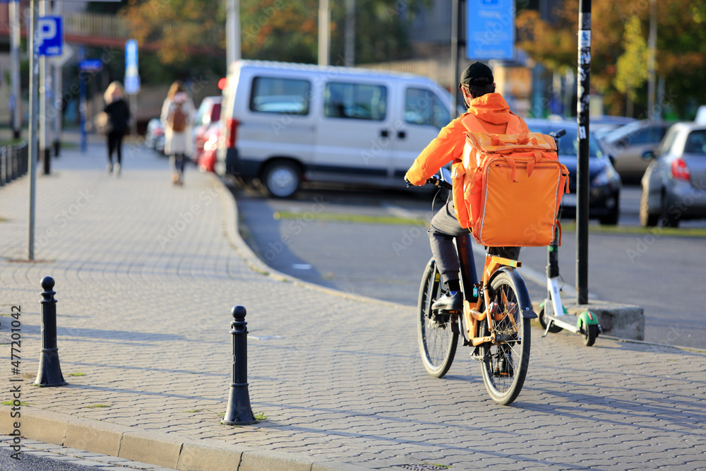 Kurier na rowerze, dostarcza jedzenie na ulicach miasta.	