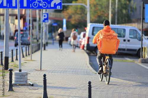 Kurier na rowerze, dostarcza jedzenie na ulicach miasta.	
