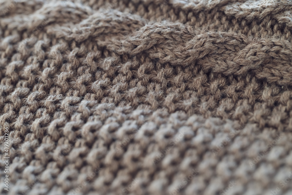 closeup of a light brown cable knit sweater with detailed yarn texture - background to create a cozy home lifestyle atmosphere closeup of a light brown cable knit sweater with detailed yarn texture - background to create a cozy home lifestyle atmosphere