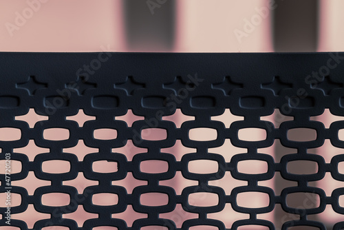 abstract pattern of silhouetted oval shapes against a neon pink background, created by the plastic back of an office chair