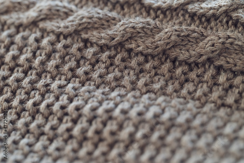 closeup of a light brown cable knit sweater with detailed yarn texture - background to create a cozy home lifestyle atmosphere