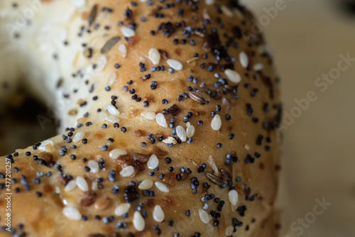 closeup view of the side of an everything bagel with poppy seeds, sesame seeds, and garlic