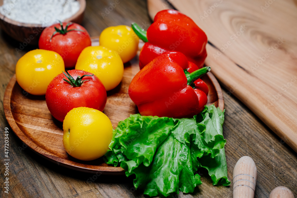 lettuce, yellow and red tomatoes and bell pepper with water drops. cucumbers.