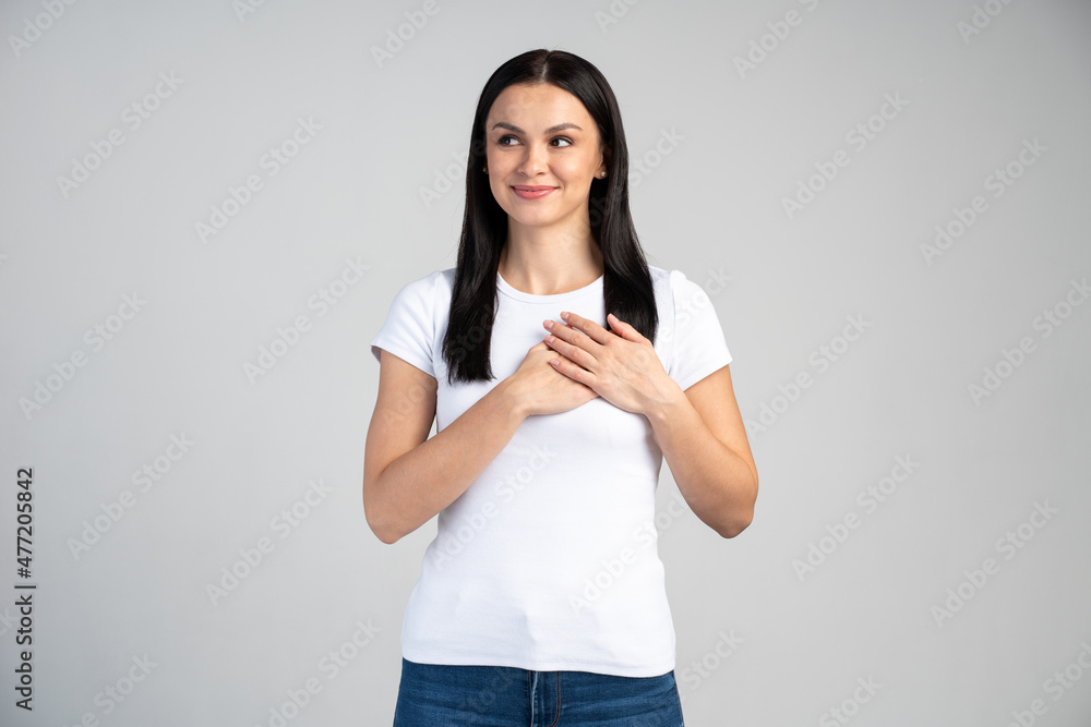 Attractive beautiful woman feeling thankful, presses palms to chest, looking with gratitude, supporting words and having confident calm expression Attractive beautiful woman feeling thankful, presses palms to chest, looking with gratitude, supporting words and having confident calm expression
