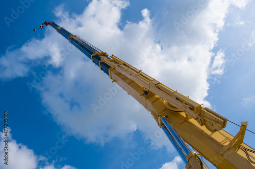 Boom crane part of mobile crane using to heavy lifting and move object in many industry such as construction, transportation, erection etc. Including with hoist lifting, hook, boom and rope with sky.