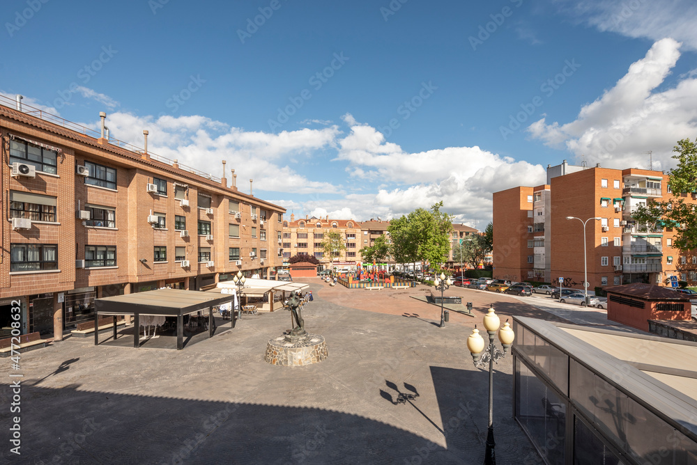 views of a square with bars and playground on a sunny day with clouds