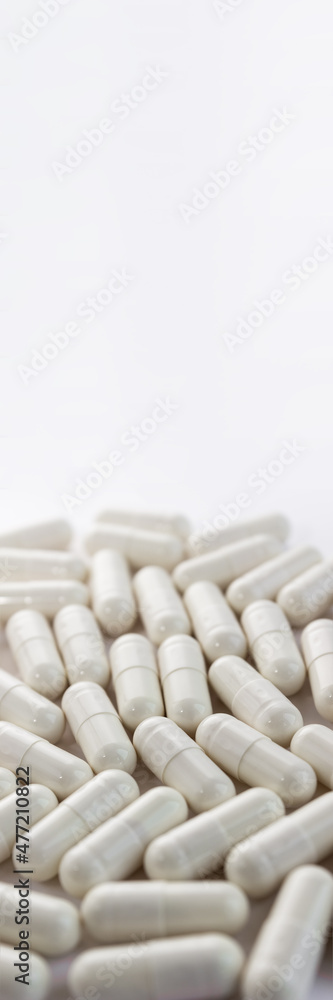 Medical pills on white background close up. Vertical banner, selective focus, copy space Medical pills on white background close up. Vertical banner, selective focus, copy space