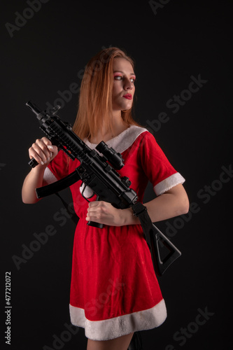 Dangerous bad Santa woman holding gun with evil smile looking at camera. 
