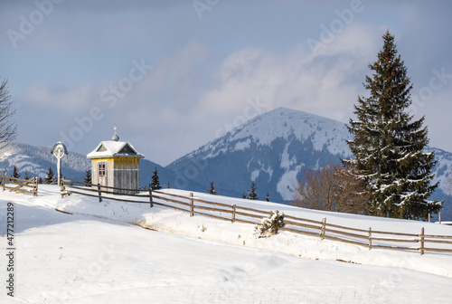 Winter remote alpine mountain village outskirts, countryside hills, groves and farmlands