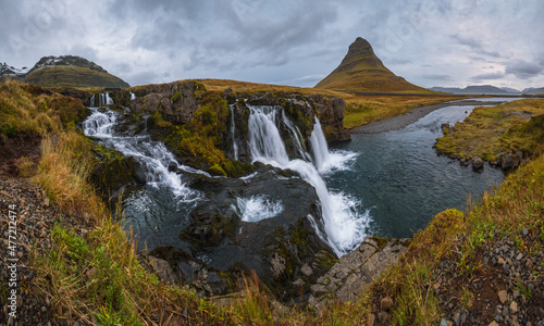 Famous picturesque Kirkjufell mountain and Kirkjufellsfoss waterfall next to Grundarfj  r  ur at West Iceland autumn view.