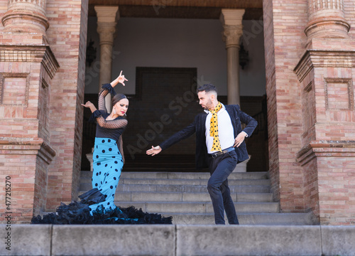 Man and woman dancing flamenco in the stairs of a traditional building