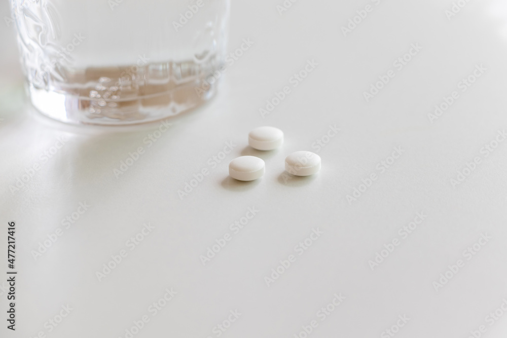 白い錠剤とグラス一杯の水 白い錠剤とグラス一杯の水