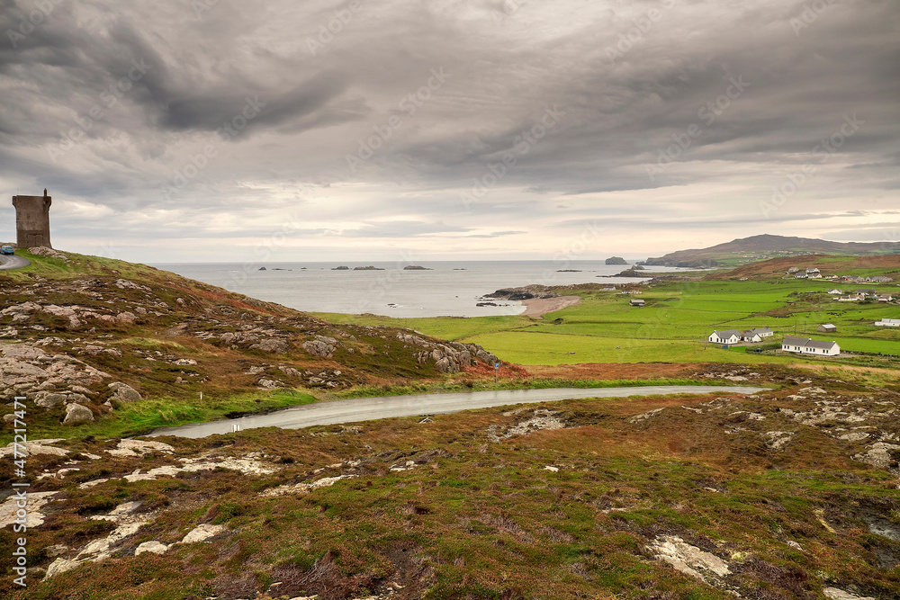 Small road to Malin head viewpoint and stunning scenery. Dark dramatic cloudy sky. Amazing Irish landscape. County Donegal, Ireland.