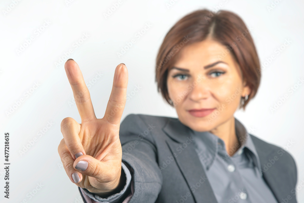 Business woman in suit shows victory sign with hand Business woman in suit shows victory sign with hand