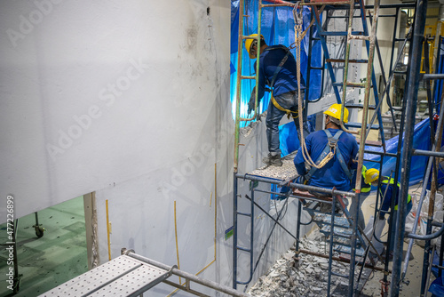 Fotografi Construction company workers are drilling a wall to demolish and prepare for new construction