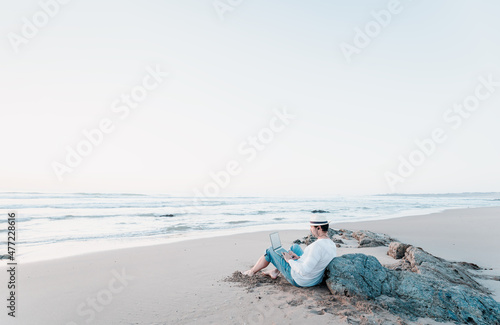 Bilde på lerret man sitting on the beach with a laptop alone doing telecommuting or remote work