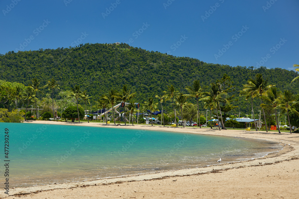 Tourquise beach with palm trees and playground in the hills
