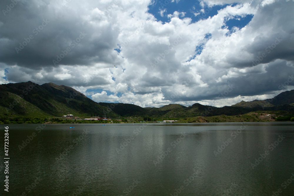 Panorama view of the reservoir Potrero de los Funes in San Luis, Argentina. The green forest, hills and lake under a dramatic sky with beautiful clouds.