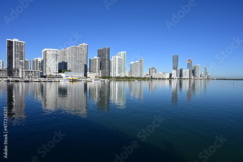 Residential waterfront towers reflected in calm waters of Biscayne Bay in Miami, Florida in early morning light..