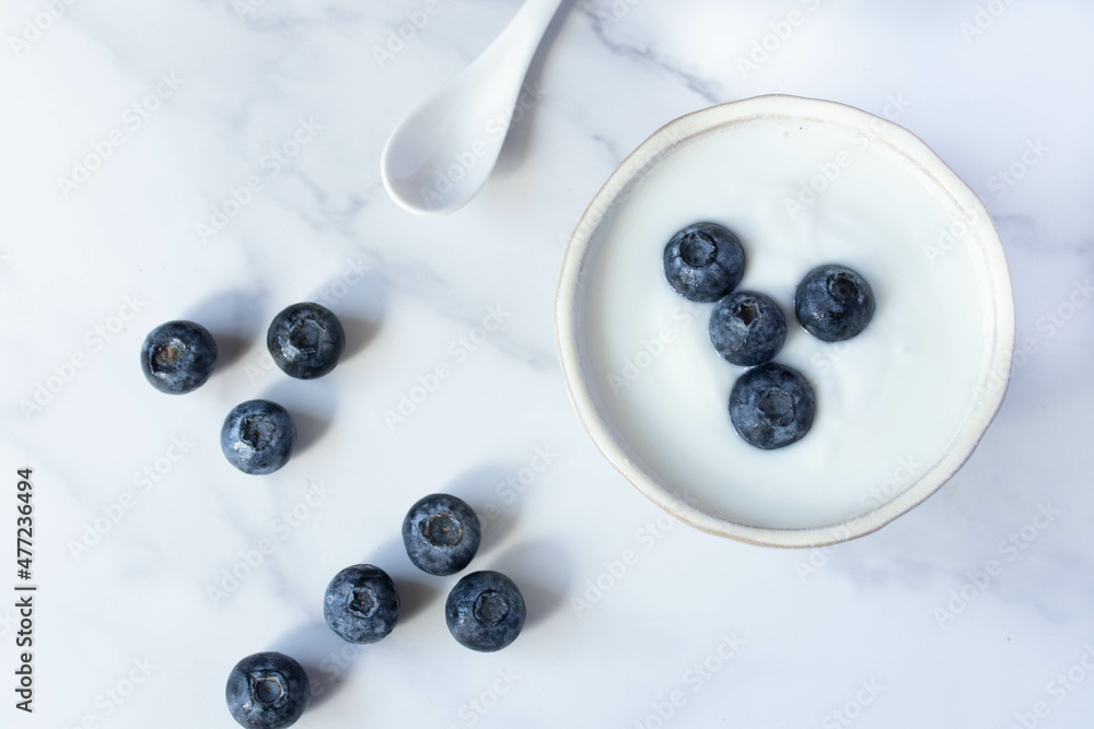 fresh blueberry yogurt in white cup on marble background fresh blueberry yogurt in white cup on marble background