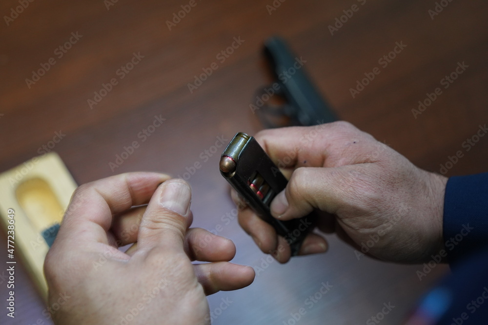 Fototapeta premium Almaty, Kazakhstan - 11.05.2021 : A police officer checks the cartridges in the pistol magazine