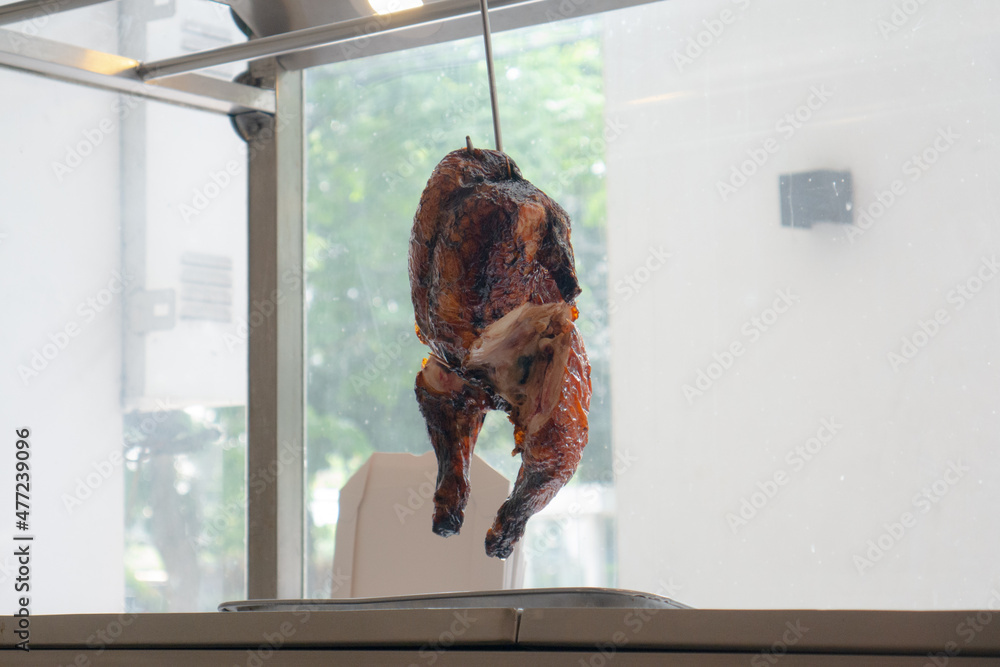 Hanged roasted chicken in restaurant. Grilled Chicken showcase hanged on hook. Chinese