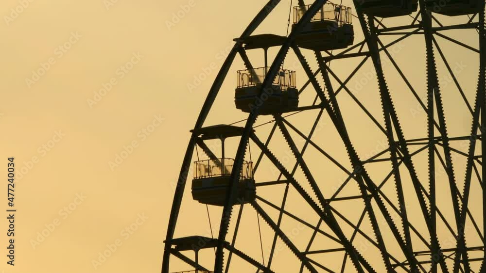 Close Up Of Ferris Wheel Silhouette Against Orange Sunset Sky. Slow Zoom Out Close Up Of Ferris Wheel Silhouette Against Orange Sunset Sky. Slow Zoom Out