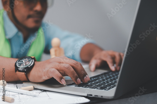 Engineer planning to work with data Through a laptop with an architecture project at a construction site at a corporate office desk. , building construction, industry 