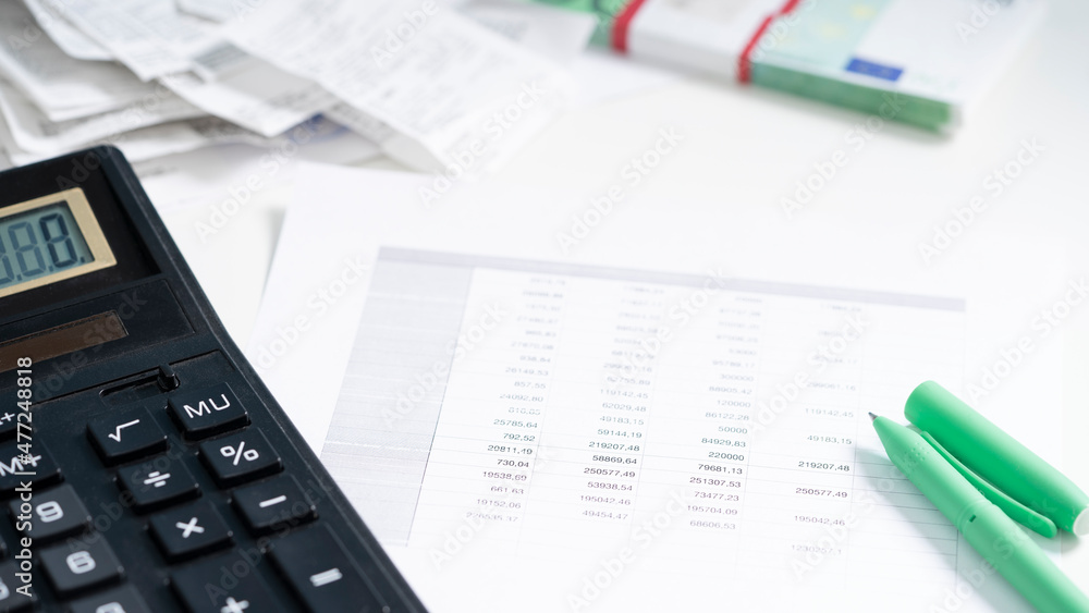 Calculator, checks and pen on white paper with numbers. Business and finance accounting concept. Calculator, checks and pen on white paper with numbers. Business and finance accounting concept.