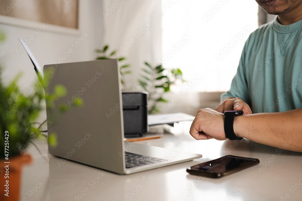 Working all day, close-up of man wearing smart watch using laptop Working all day, close-up of man wearing smart watch using laptop