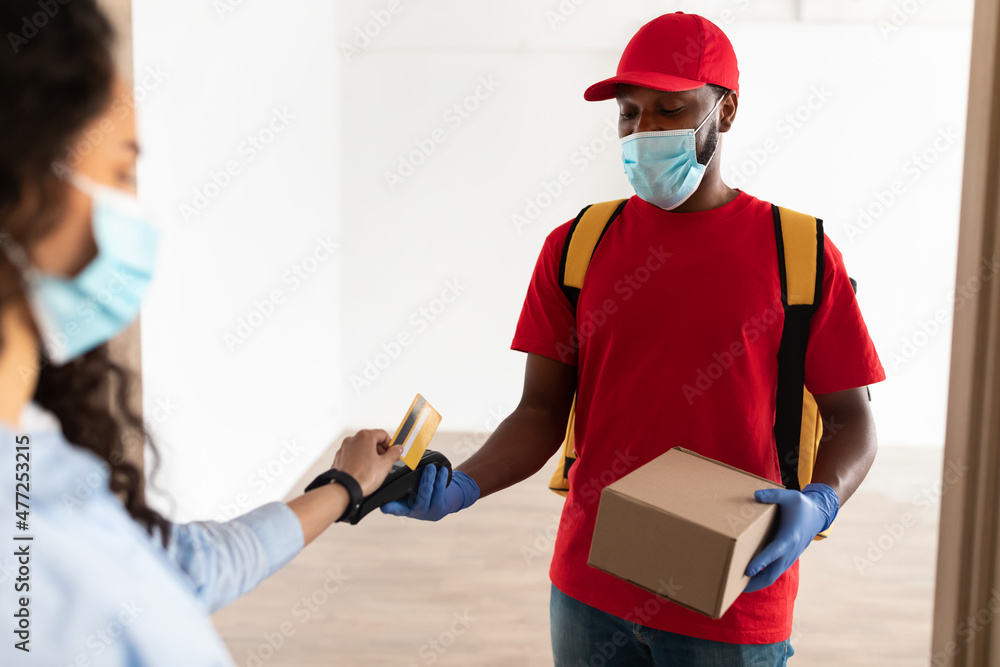 Black man holding POS machine lady paying with debit card Black man holding POS machine lady paying with debit card