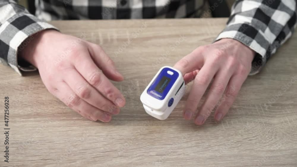 A man checking oxygen level at home with home pulse oximeter, patient