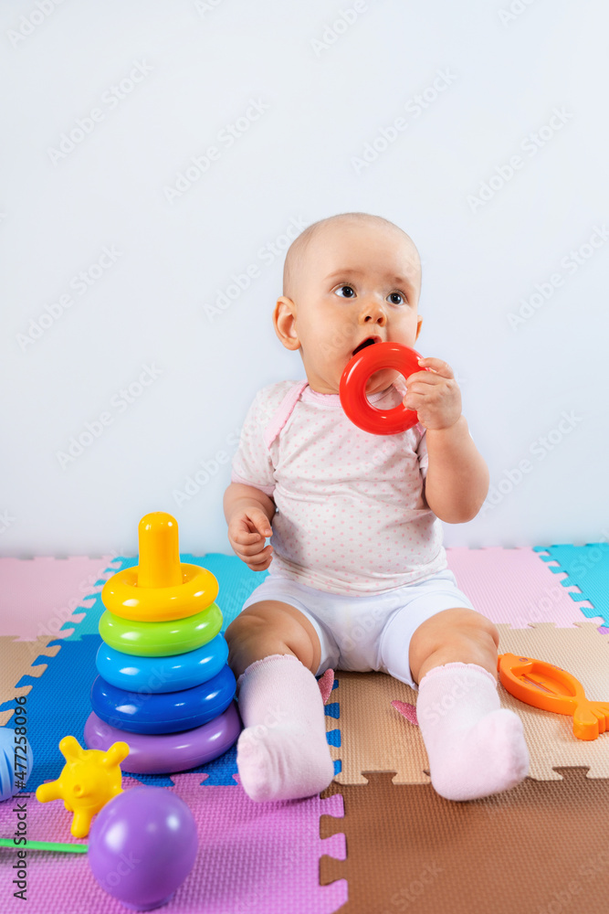 Happy baby is playing with a toy pyramid. Educational toys for toddlers