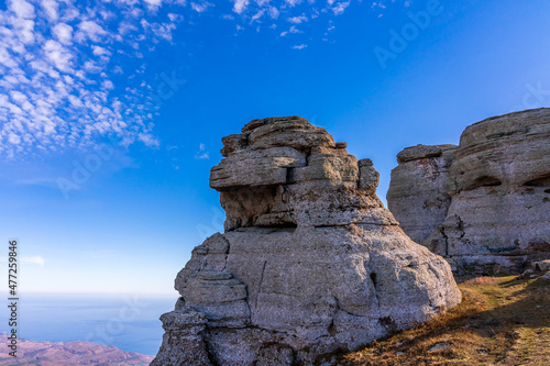 Calcareous stone statues of various unusual shapes on the top of the South Demerdzhi mountain against a blue sky