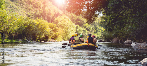 people rafting on the river turbulent flow with sunbeam. Extreme and enjoyment sport.