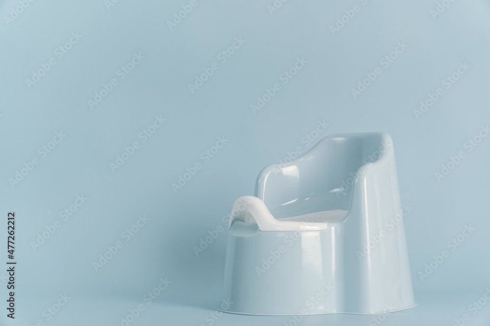 Blue plastic baby pot with a back on a blue background, copyspace Blue plastic baby pot with a back on a blue background, copyspace