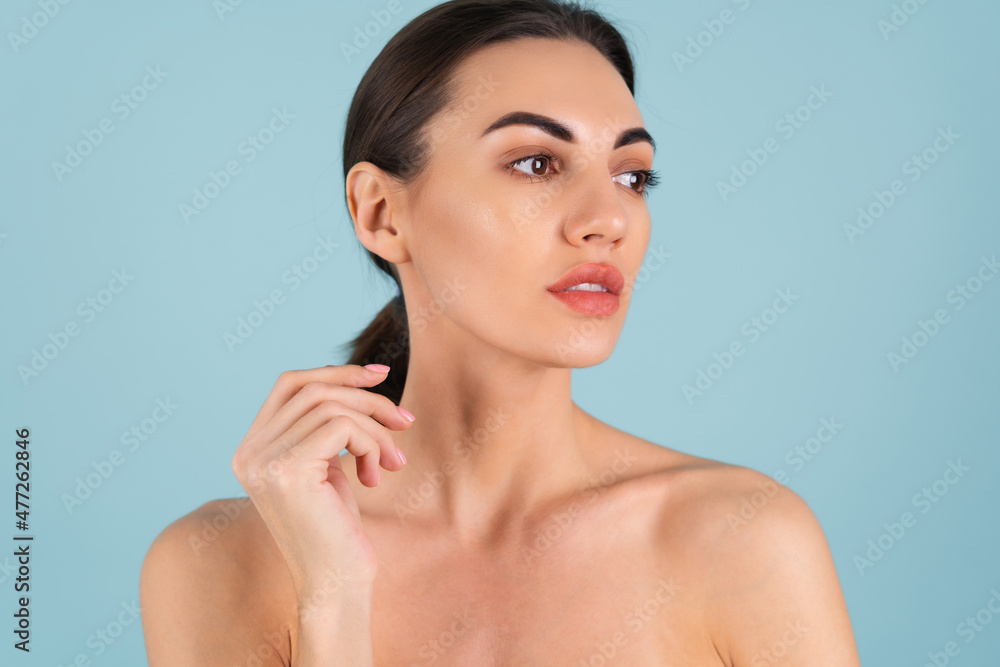 Close beauty portrait of a topless woman with perfect skin and natural make-up, plump nude lips, on a blue background Close beauty portrait of a topless woman with perfect skin and natural make-up, plump nude lips, on a blue background