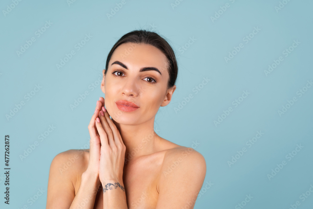 Close beauty portrait of a topless woman with perfect skin and natural make-up, plump nude lips, on a blue background Close beauty portrait of a topless woman with perfect skin and natural make-up, plump nude lips, on a blue background