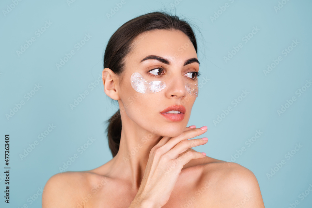 Close beauty portrait of a topless woman with perfect skin and natural make-up, shiny patches under the eyes, to moisturize the skin and relieve puffiness of the face Close beauty portrait of a topless woman with perfect skin and natural make-up, shiny patches under the eyes, to moisturize the skin and relieve puffiness of the face