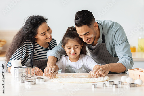 Cute loving family baking together, having flour on faces