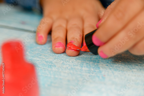 Nail polish in the hands of a child. Children wear their parents  makeup.