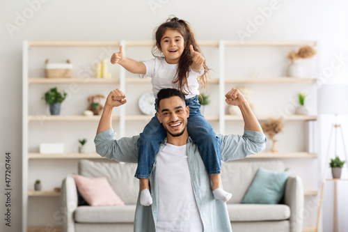 Playful middle-eastern father and daughter having fun at home