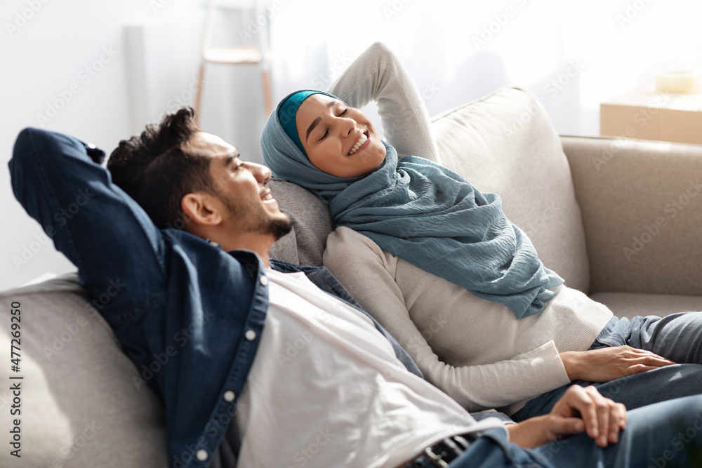 Relaxed muslim family resting after moving to their new house