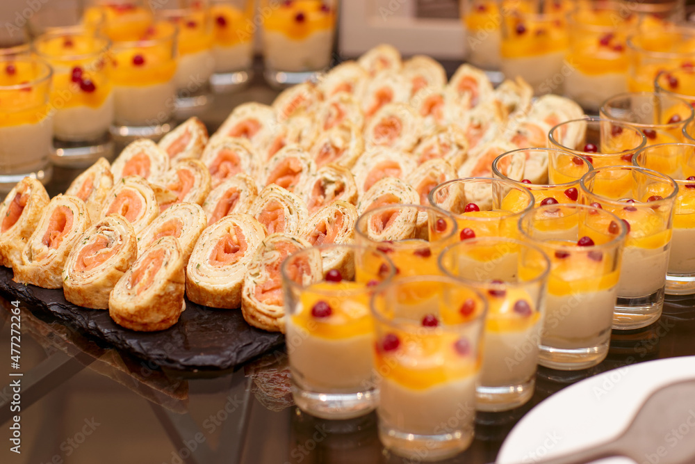 Pancakes rolls with salmon and glasses of panna cotta Pancakes rolls with salmon and glasses of panna cotta
