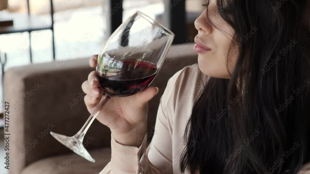 Beautiful brunette girl is drinking red wine and relaxing slow motion Beautiful brunette girl is drinking red wine and relaxing slow motion
