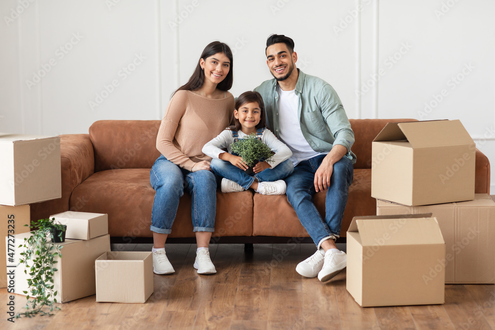 Positive young family looking at camera, posing in new apartment Positive young family looking at camera, posing in new apartment